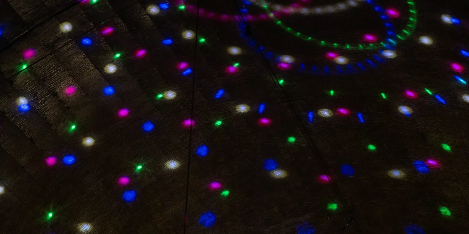 Un plafond sombre parsemé de petits points lumineux colorés