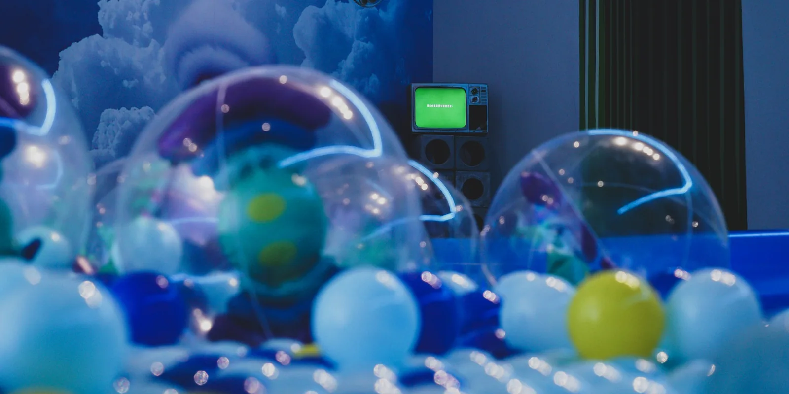 Des boules transparentes et colorées dans une pièce aux lumières bleues