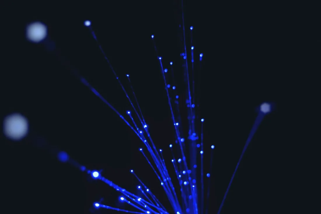 Une seule fibre optique bleue lumineuse sur fond noir
