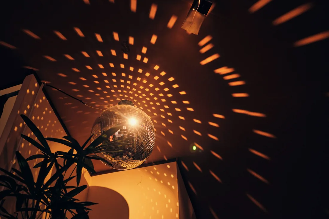 Des taches de lumière dorée projetées par une boule à facettes